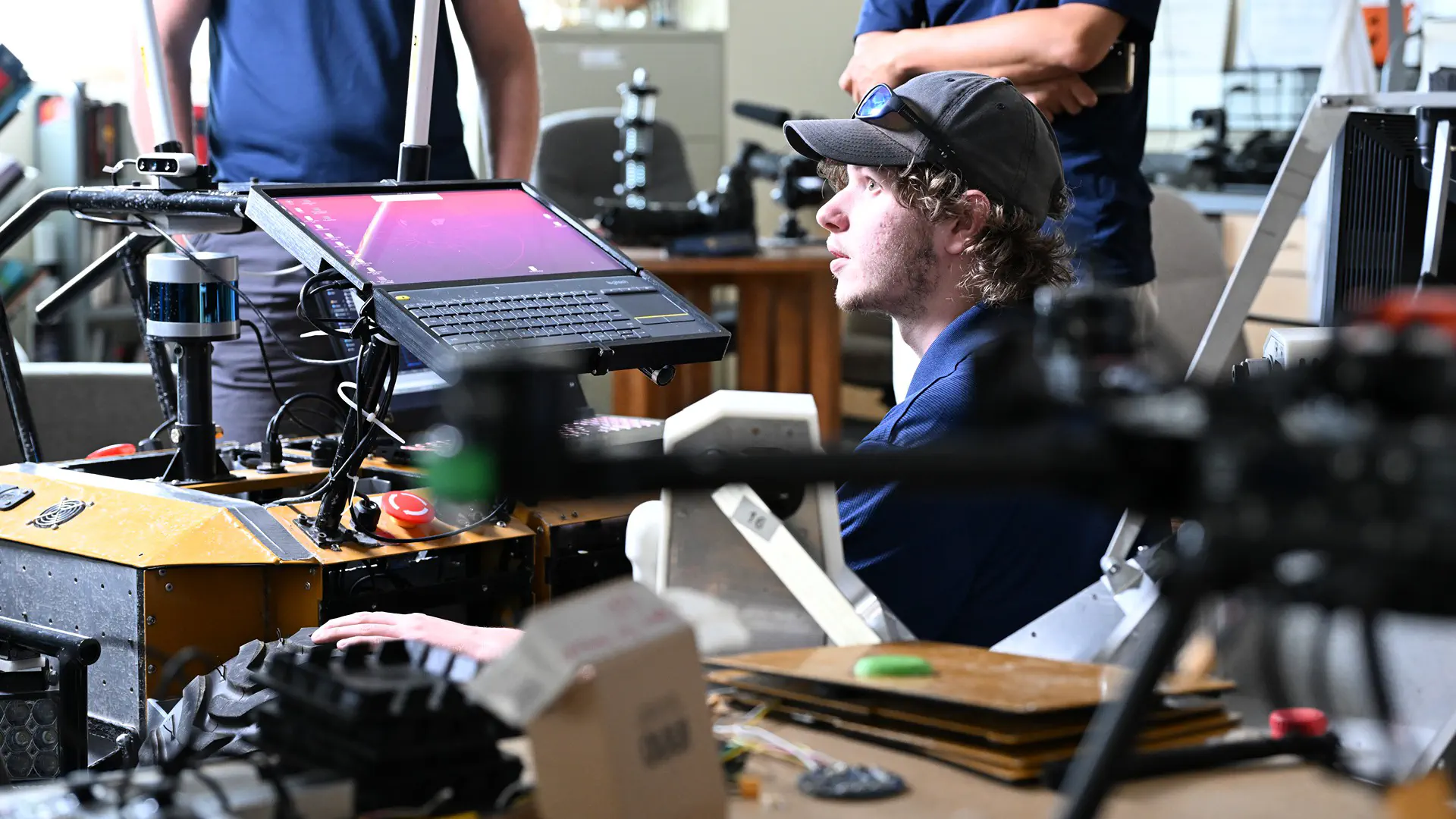 Students work on a rover in a desert landscape.