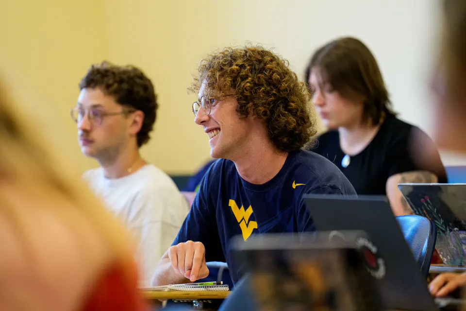 Students sitting and smiling in a lecture hall.