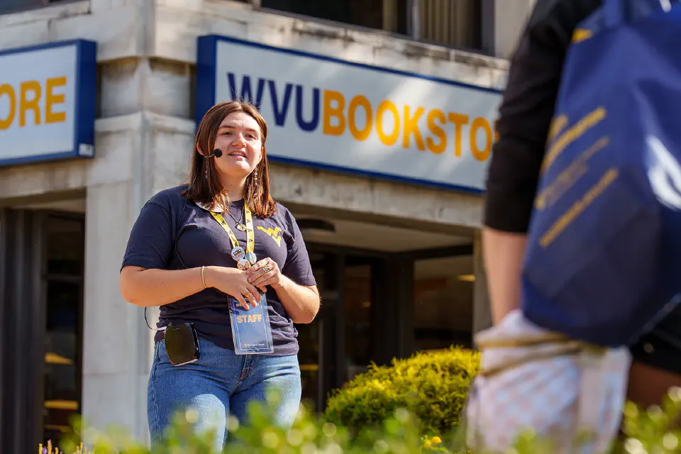 A campus tour guide speaking to their tour group