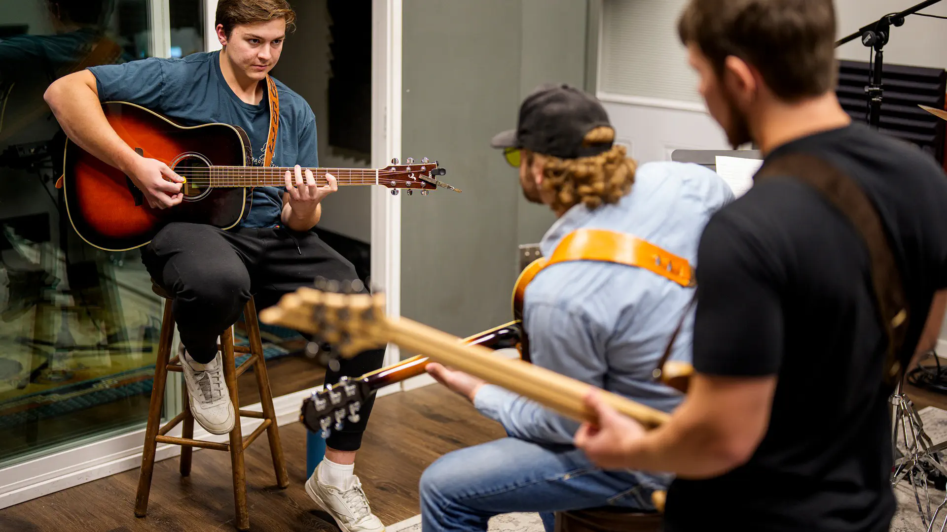 College of Creative arts entryway lined by bright flowers and a large metal sculpture