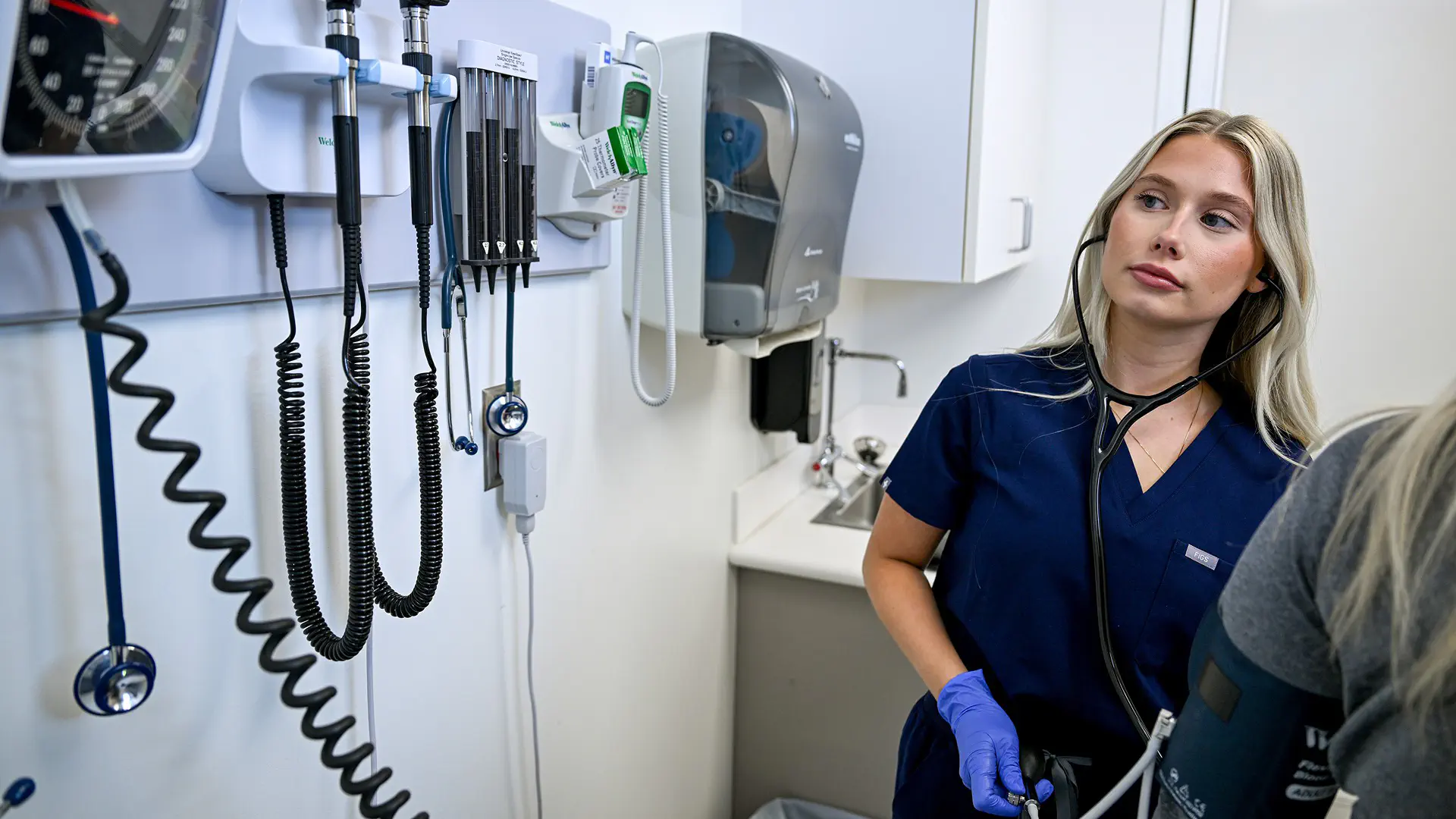 Student and faculty member working with a patient