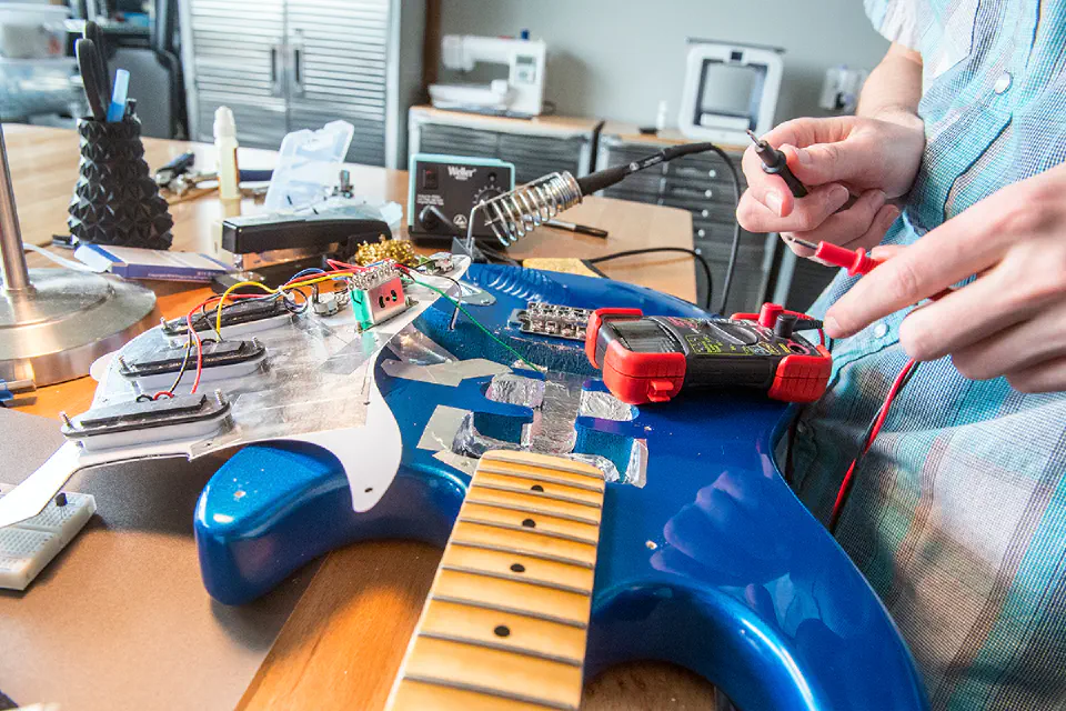 A student working on an electric guitar in the Morris L. Hayhurst Launchlab