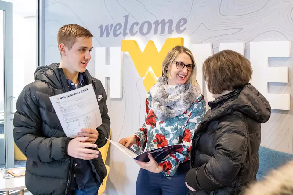 WVU staff member talks with a family at the Evansdale Visitors Center