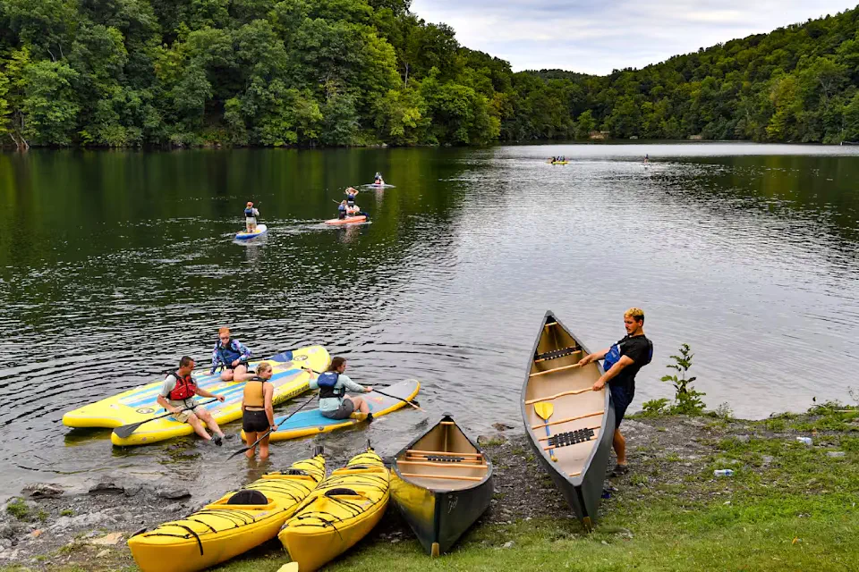 People launching kayaks, canoes and paddle boards onto the Cheat Lake backwaters.