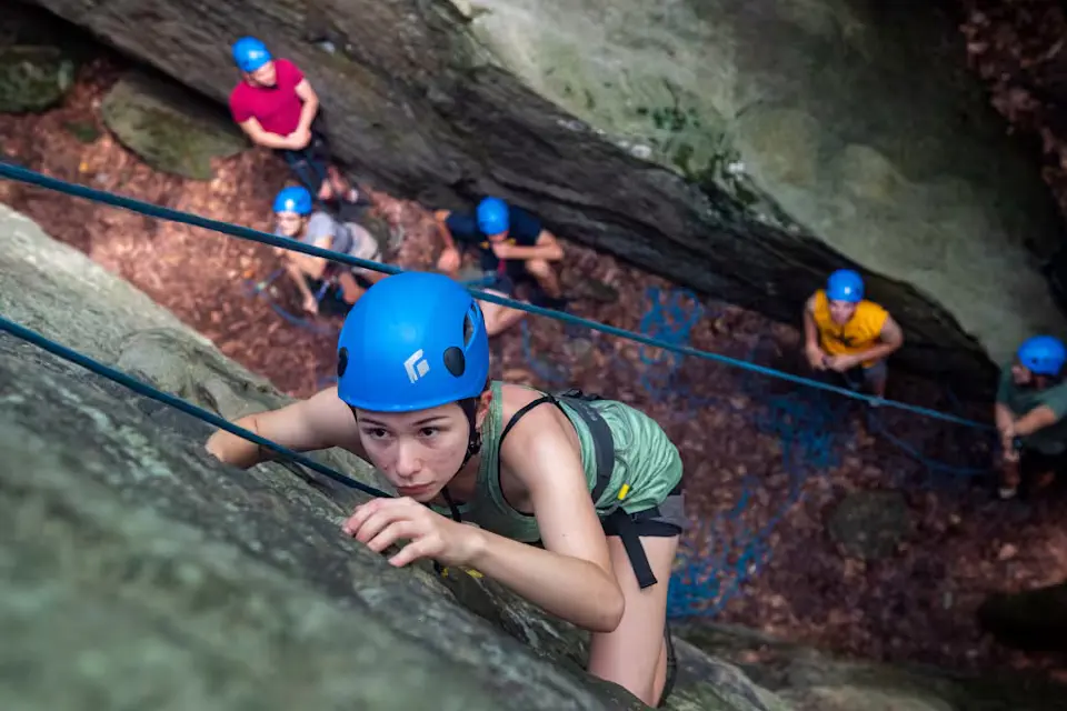 A student ascends a rock face at Coopers Rock.