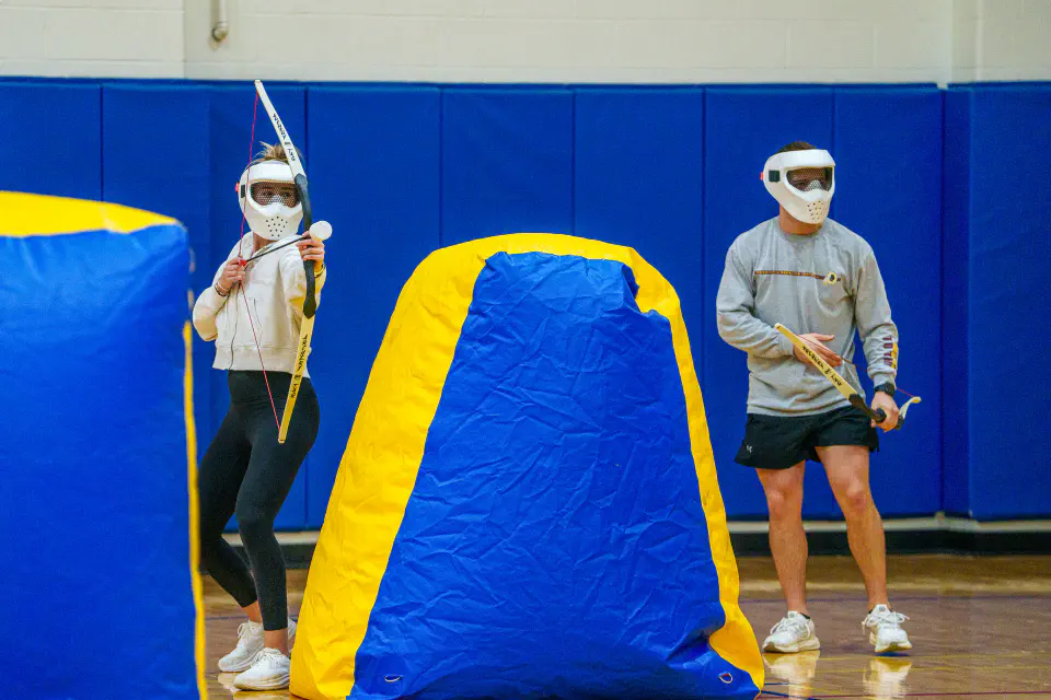 Students playing archery tag in the Student Recreation Center at the WVU Midnight Mountaineer event.