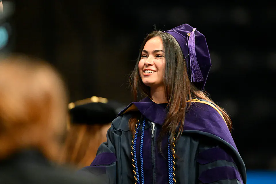 WVU College of Law student walking the graduation stage to receive their diploma