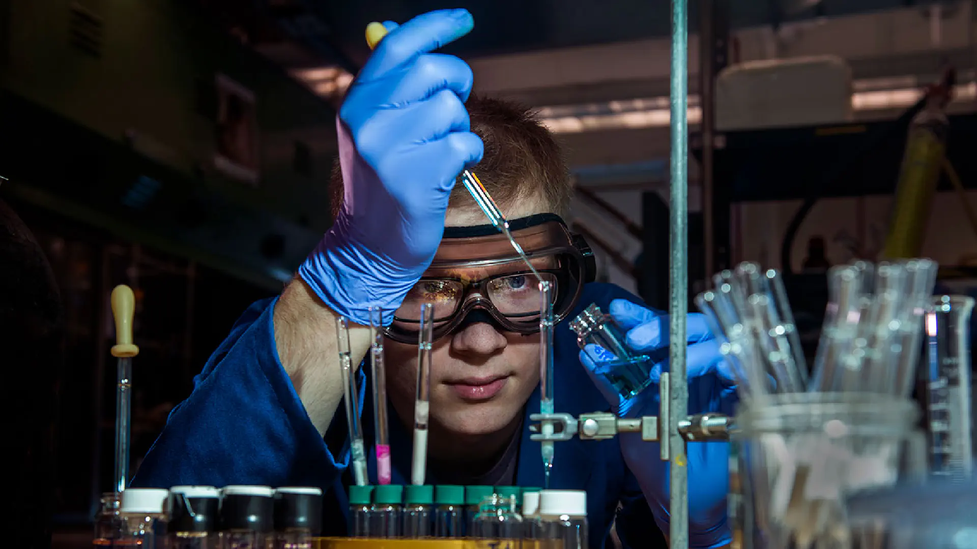 Person dropping liquid into a test tube