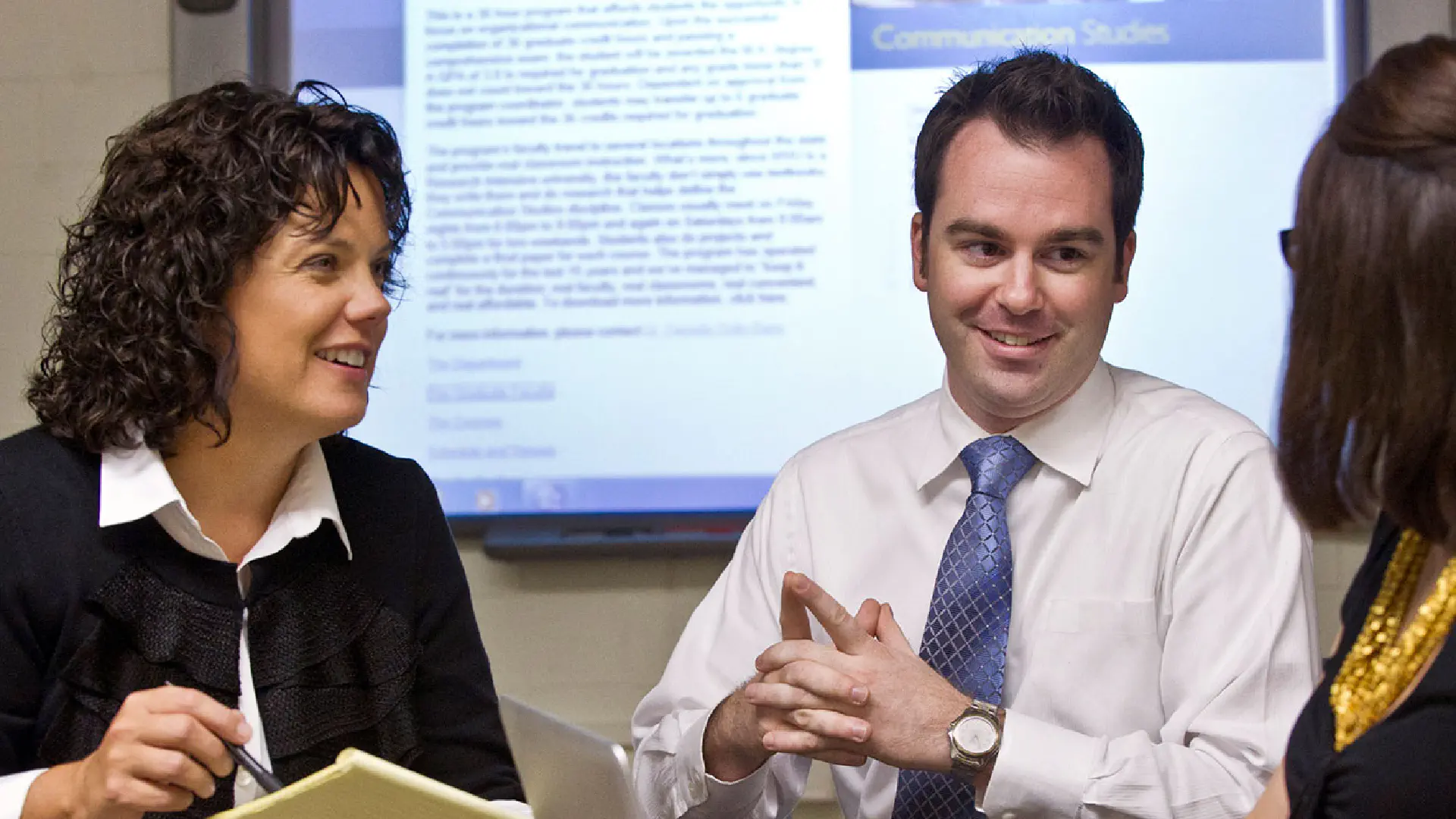 3 people having a conversation in an office setting