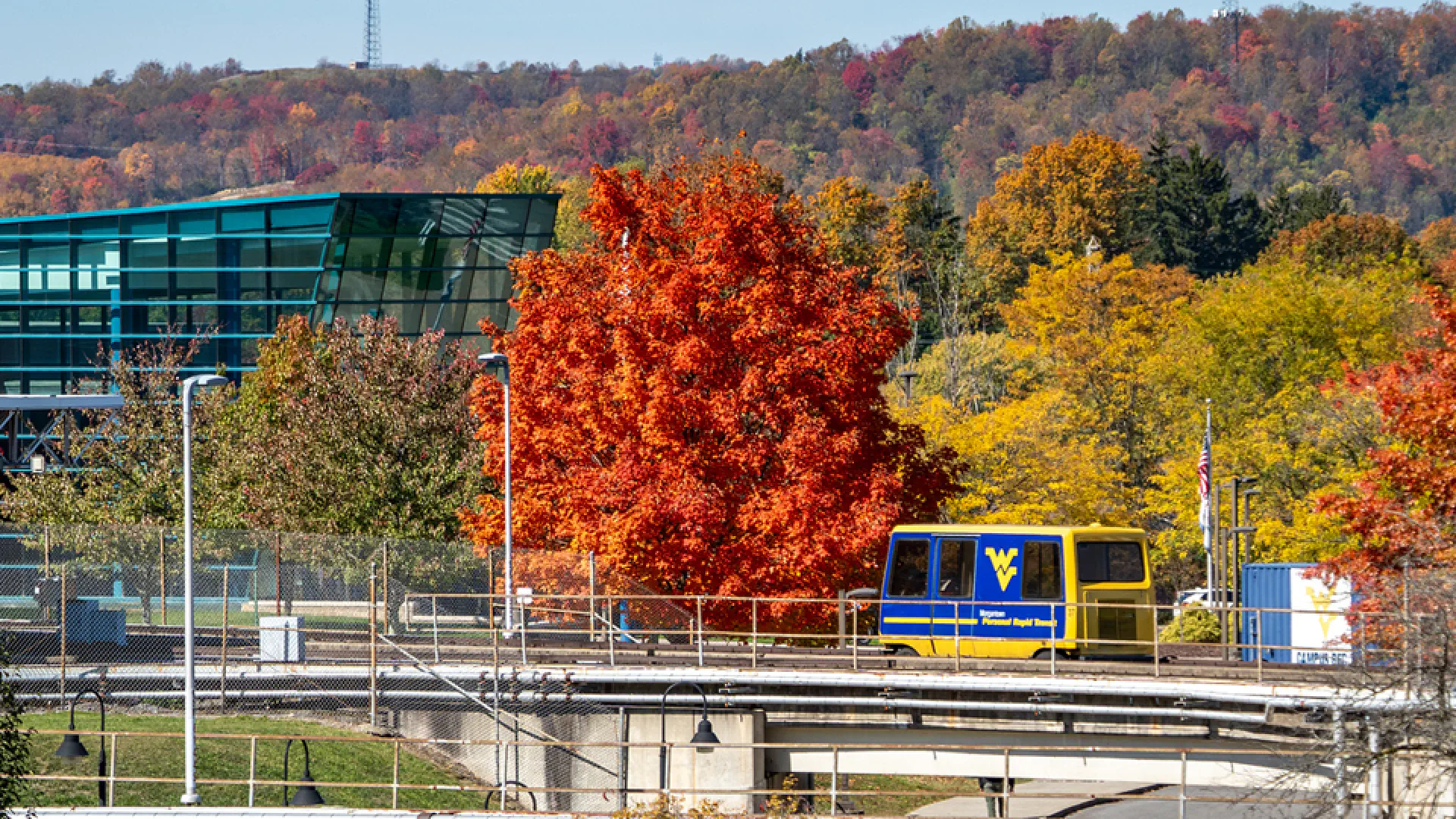 PRT passes by Student Rec Center and trees with fall colors.