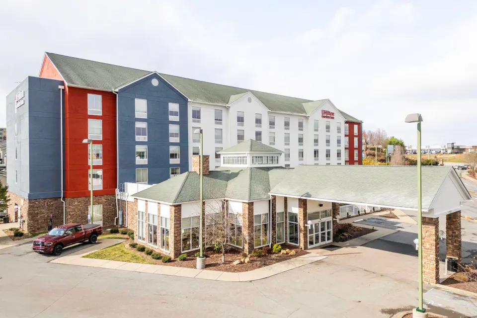 5-story modern hotel building with wide drive-through unloading area