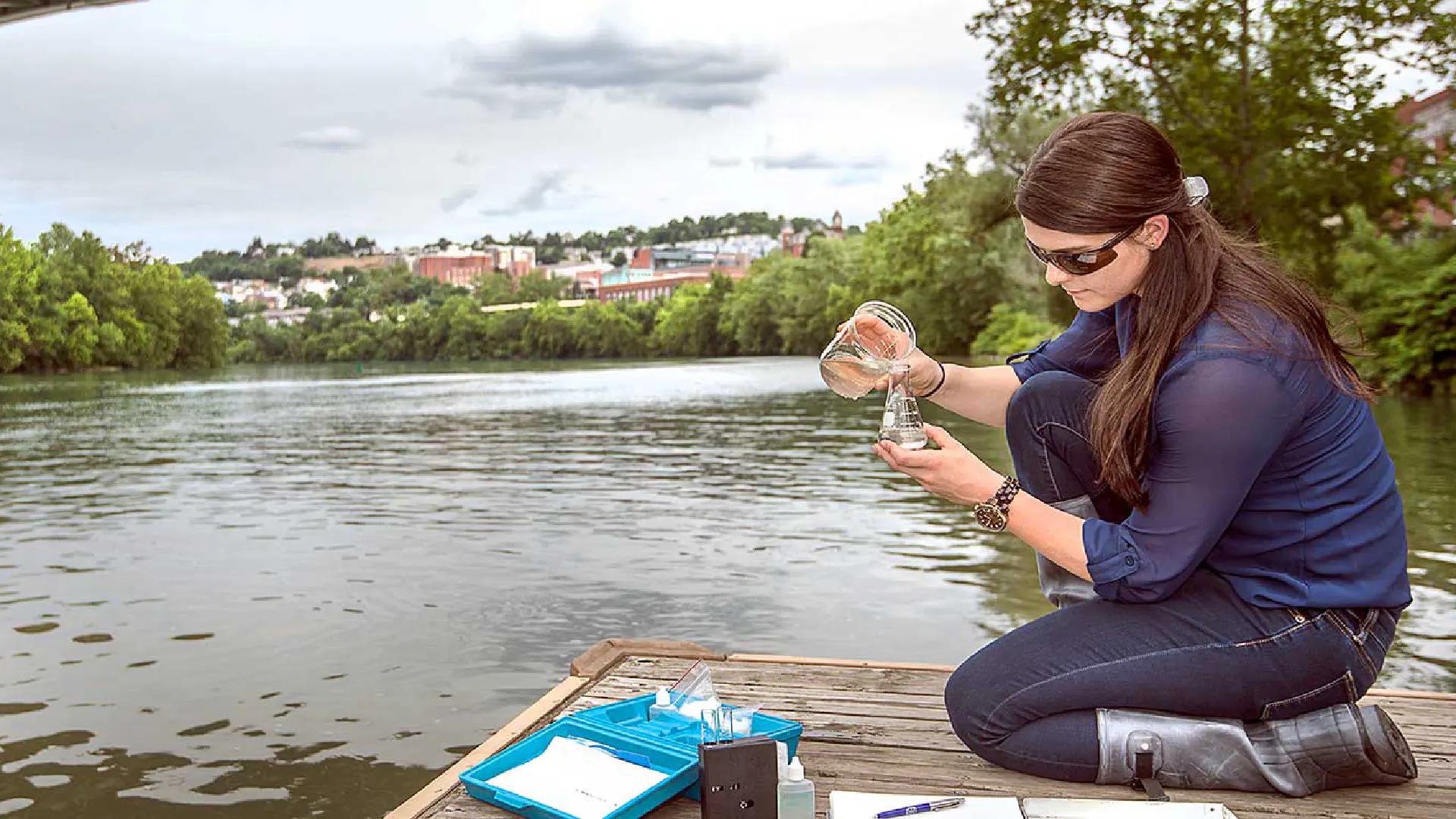 Person collecting water sample from the Monongahela River near campus