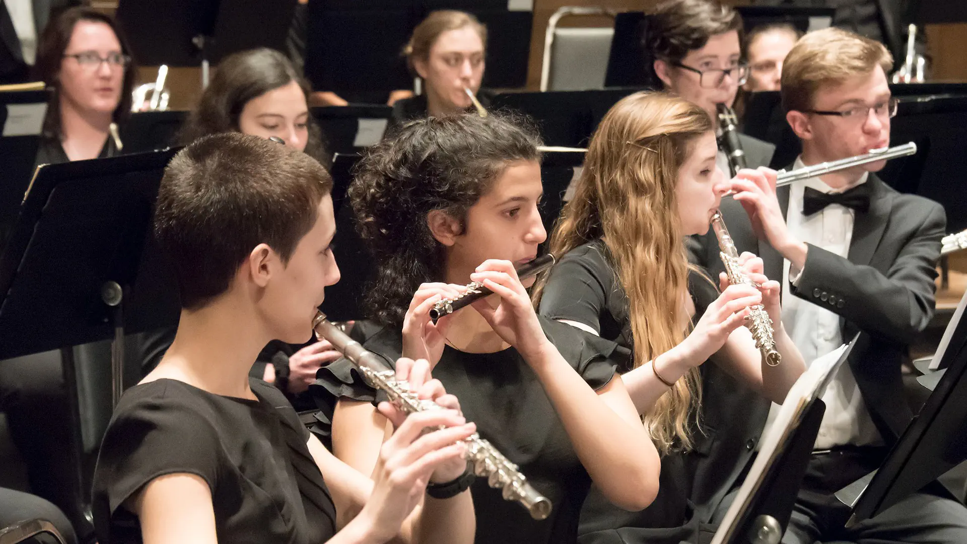 Students playing flute at a concert