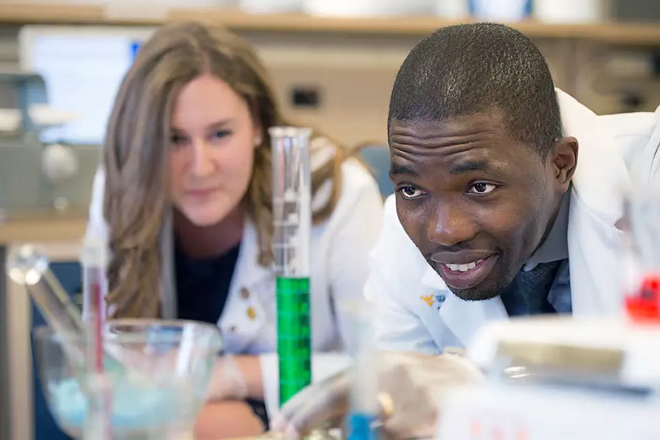 Pharmacy student measures liquid in beaker