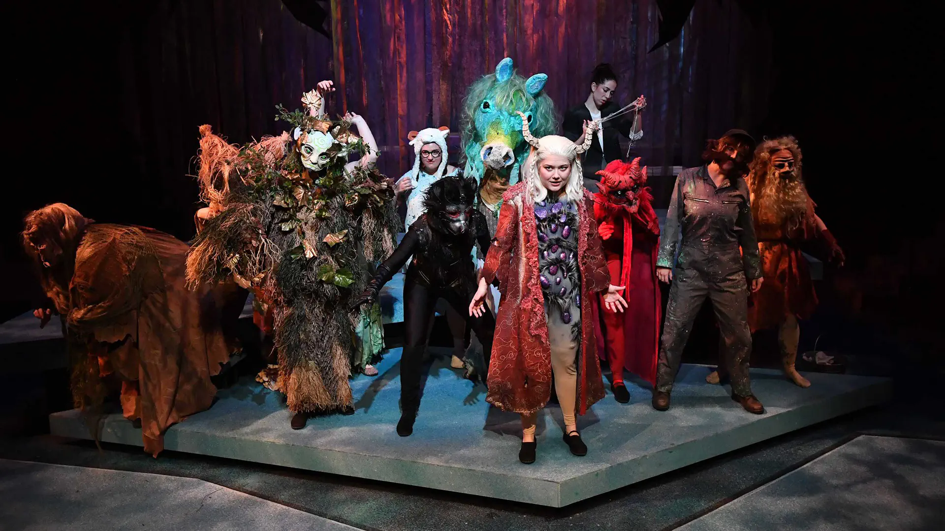 group of costumed actors on stage during a performance