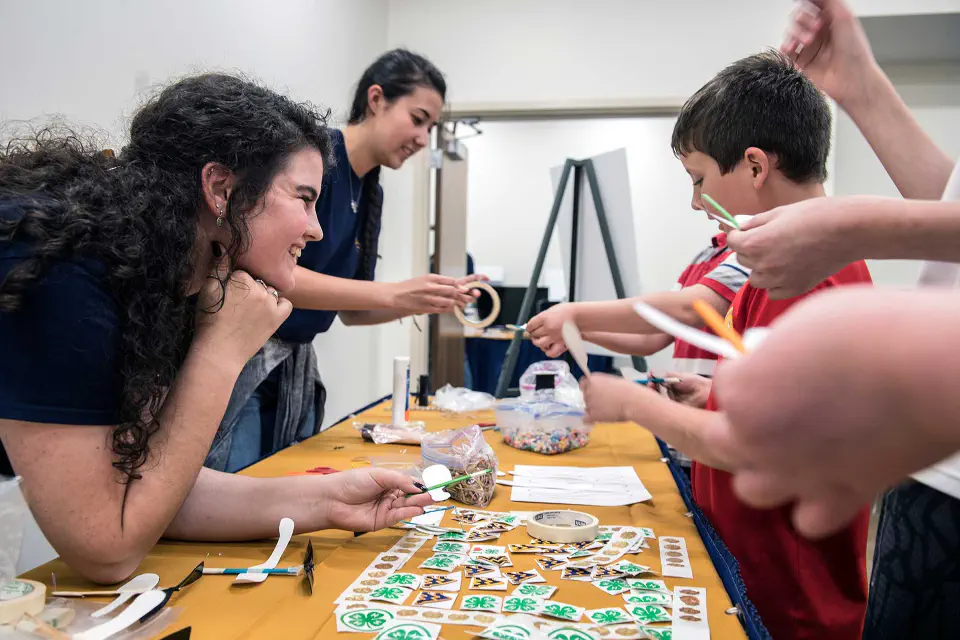 Students working with children at a STEM-based event
