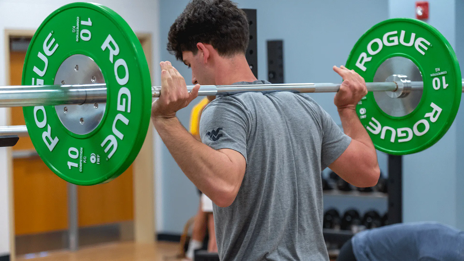 Student lifting barbell